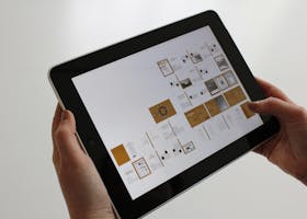 Close-up of hands using a tablet, displaying a digital interface.